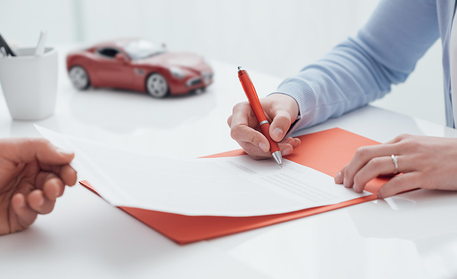 A woman signing her car insurance in California