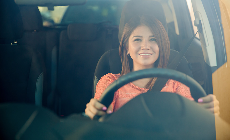 A smiling woman driving